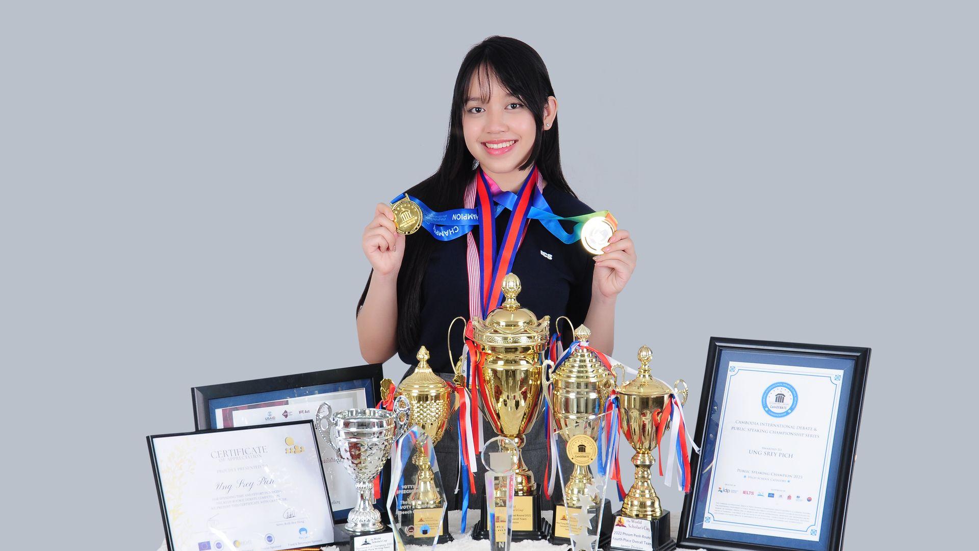 Student with trophies and certificates